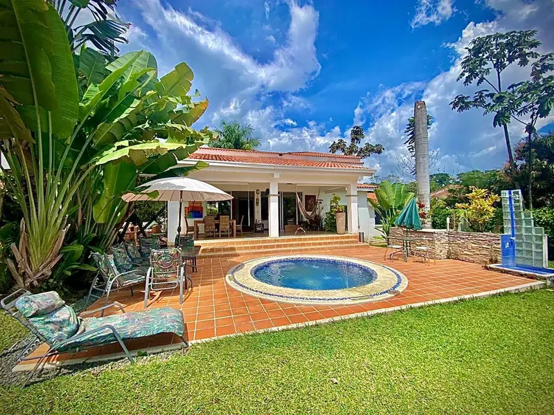 Fachada frontal de una casa campestre en el condominio Arrecife, con terraza y jardín
